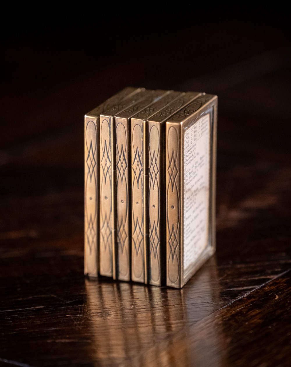 A nineteenth-century six-fold miniature brass frame holding printed paper London almanac sheets dated 1878. View VII