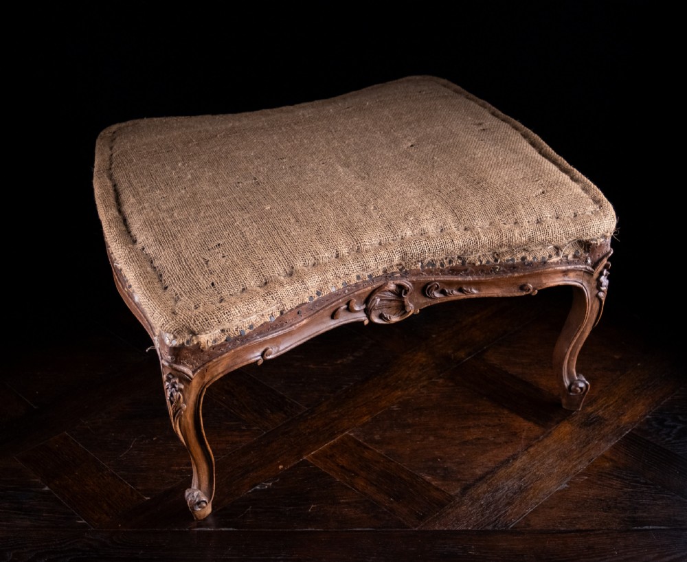A low rectangular Louis XV style footstool featuring a carved beech frame, cabriole legs, shell motifs, and hessian upholstery. View III