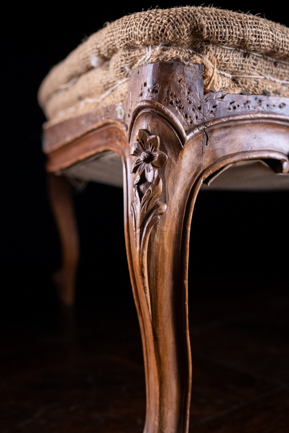 A low rectangular Louis XV style footstool featuring a carved beech frame, cabriole legs, shell motifs, and hessian upholstery. View X