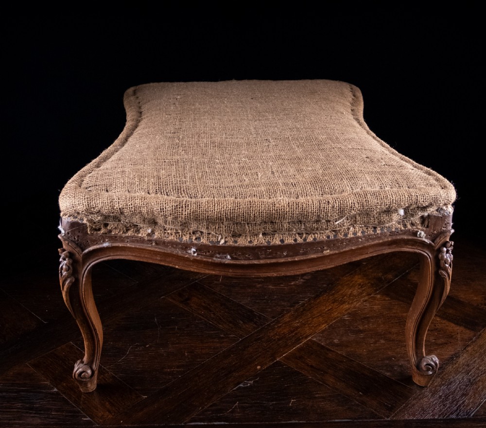 A low rectangular Louis XV style footstool featuring a carved beech frame, cabriole legs, shell motifs, and hessian upholstery. View XII