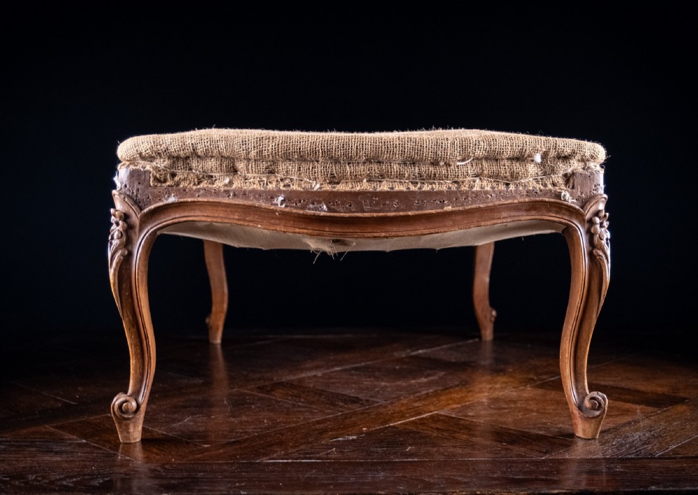 A low rectangular Louis XV style footstool featuring a carved beech frame, cabriole legs, shell motifs, and hessian upholstery. View XIII