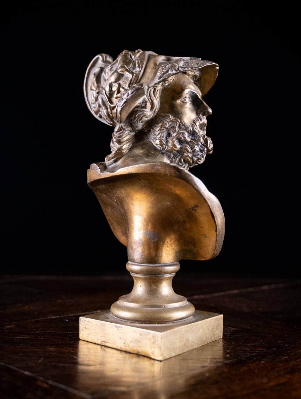 A nineteenth-century gilt bronze sculptural bust depicting the classical hero Ajax in profile, wearing an ornate helmet and mounted on a turned pedestal base. View X