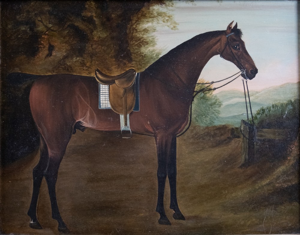 Early 19th-century oil painting on board depicting a saddled bay hunter horse standing in profile within a rural landscape, presented in a light wood frame. View II