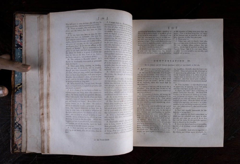 A two-volume set of 18th-century calfskin leather-bound books displaying gilt-tooled spines with red and green title labels. View XV
