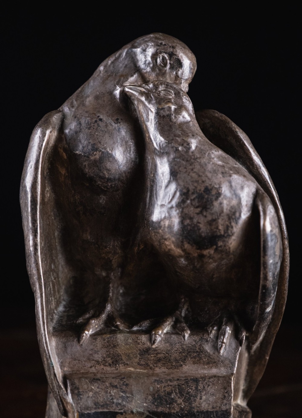 A dark nickel bronze sculpture depicting two stylised pigeons resting together on an integrated rectangular base. View II