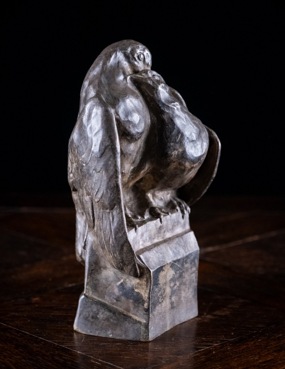 A dark nickel bronze sculpture depicting two stylised pigeons resting together on an integrated rectangular base. View V
