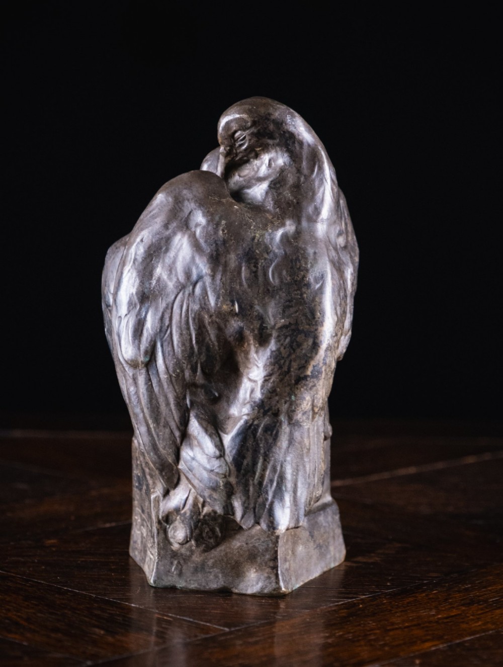 A dark nickel bronze sculpture depicting two stylised pigeons resting together on an integrated rectangular base. View VII