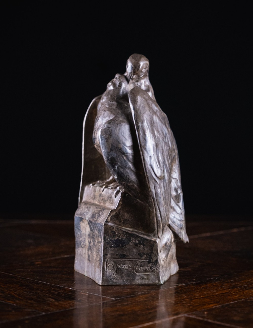 A dark nickel bronze sculpture depicting two stylised pigeons resting together on an integrated rectangular base. View VIII