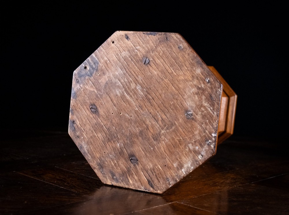 An octagonal oak tabletop post box featuring a brass letter slot marked LETTERS and a key-locked front door with a collection schedule frame. View XIII