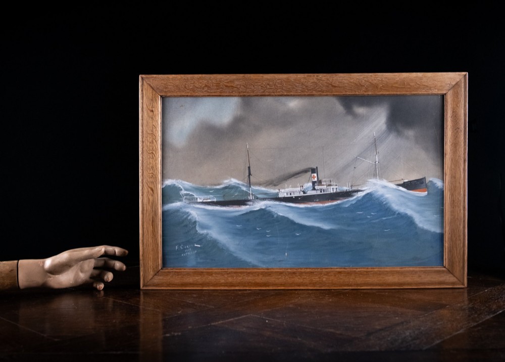 An Edwardian gouache painting depicting a steamship navigating rough blue ocean waves under a dark, stormy sky, encased in a plain oak frame. View X