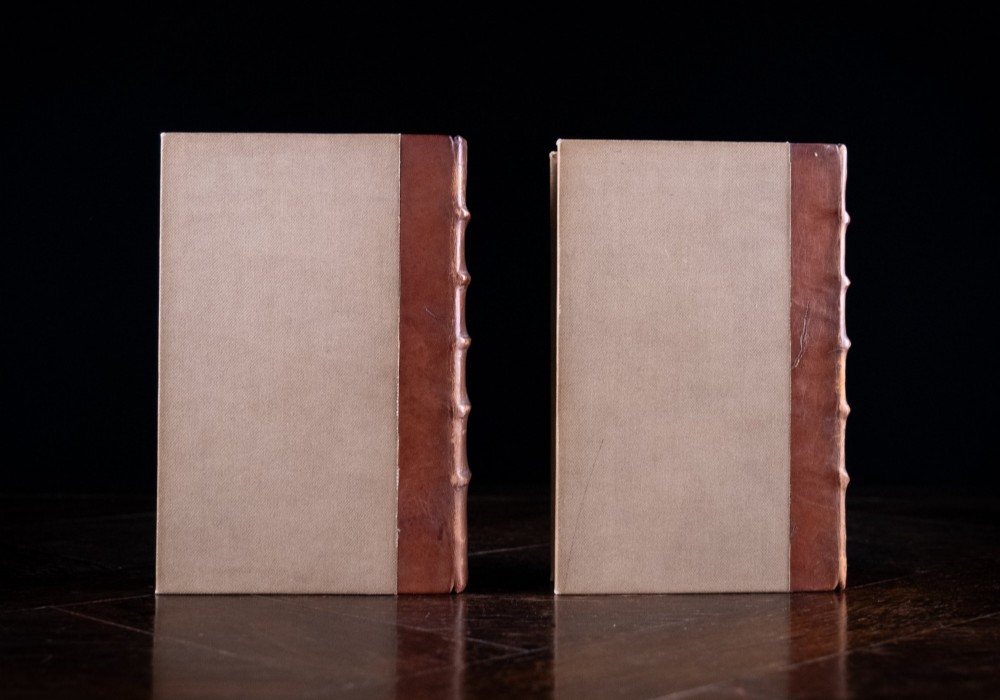 A two-volume set of 1899 first edition books titled The Life of William Morris, bound in brown leather spines with gilt lettering and cream cloth boards. View IV