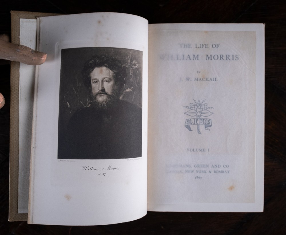 A two-volume set of 1899 first edition books titled The Life of William Morris, bound in brown leather spines with gilt lettering and cream cloth boards. View IX