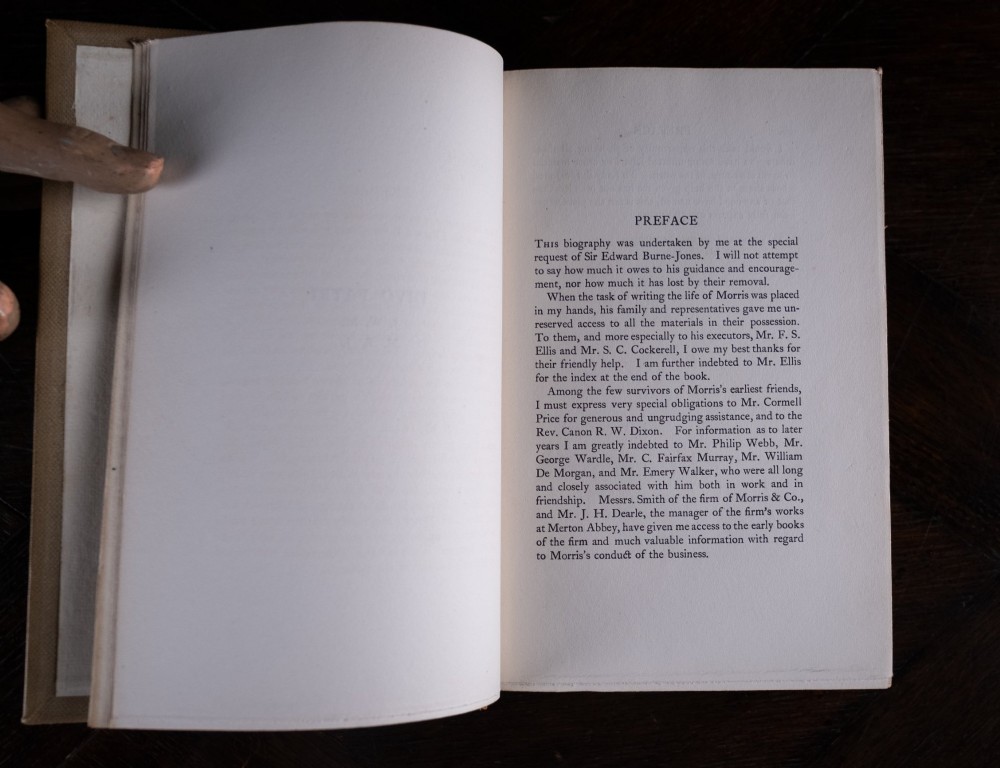 A two-volume set of 1899 first edition books titled The Life of William Morris, bound in brown leather spines with gilt lettering and cream cloth boards. View X