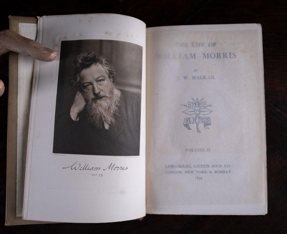 A two-volume set of 1899 first edition books titled The Life of William Morris, bound in brown leather spines with gilt lettering and cream cloth boards. View XIII