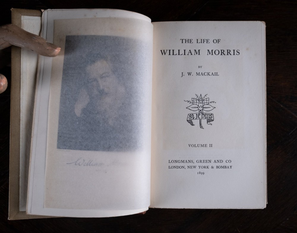 A two-volume set of 1899 first edition books titled The Life of William Morris, bound in brown leather spines with gilt lettering and cream cloth boards. View XIV