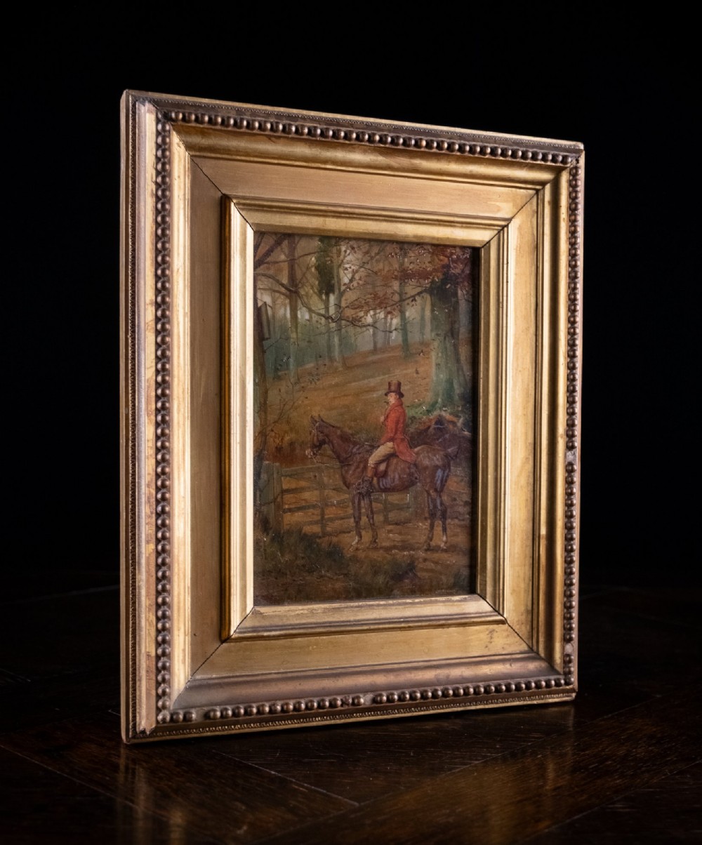 A 19th-century oil painting on panel depicting a gentleman in a red hunting coat atop a horse next to a timber gate in autumn woods. View VII