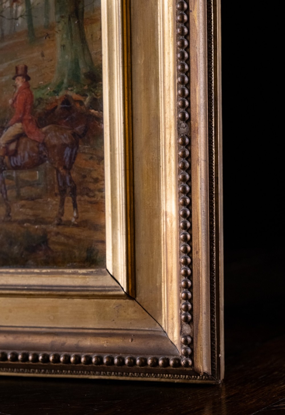 A 19th-century oil painting on panel depicting a gentleman in a red hunting coat atop a horse next to a timber gate in autumn woods. View IX