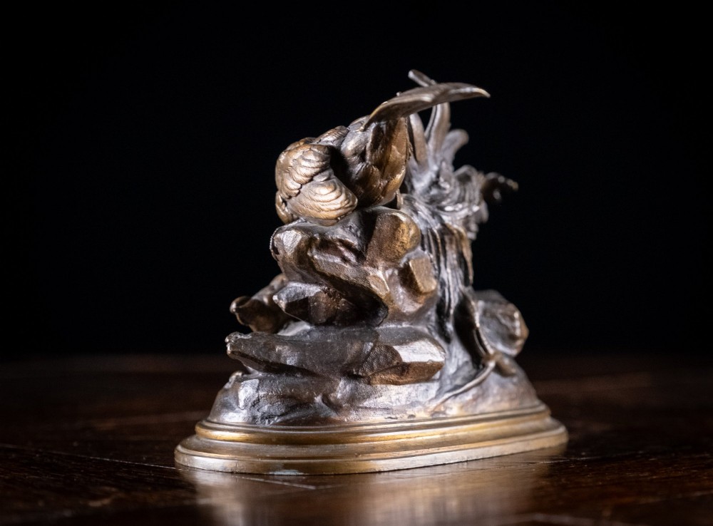 A 19th-century dark patinated bronze sculpture depicting parent birds and fledglings surrounding a foliage nest on an oval base. View VIII