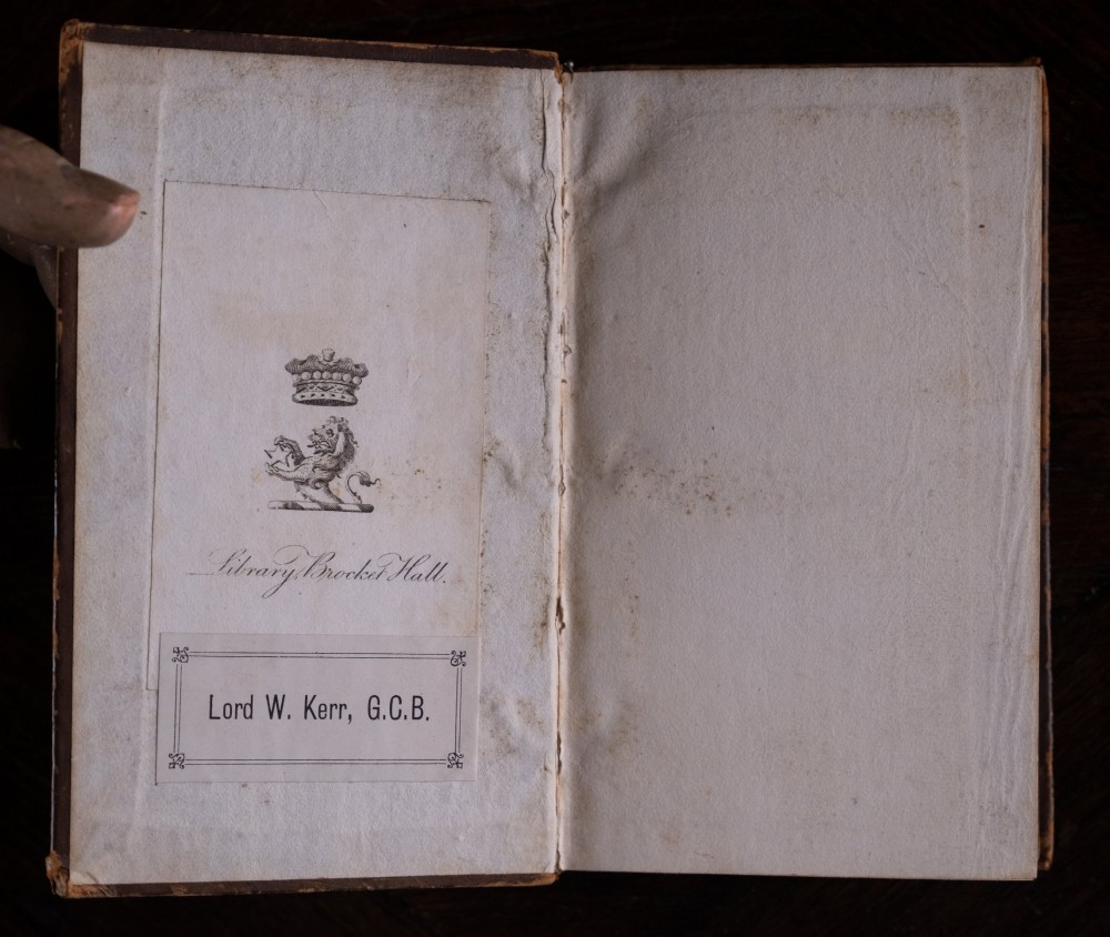 An eight-volume set of 18th-century leather-bound books standing upright with visible raised spine bands and gilt titles. View VI