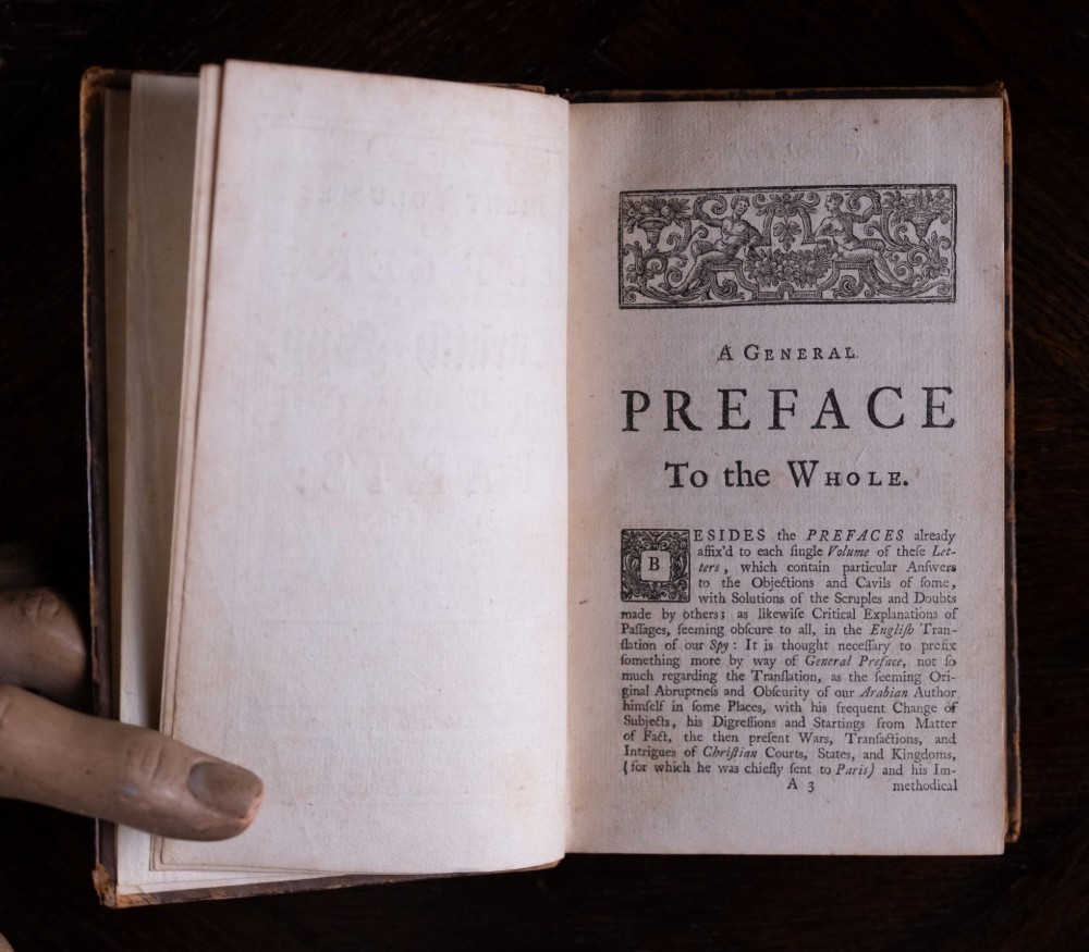 An eight-volume set of 18th-century leather-bound books standing upright with visible raised spine bands and gilt titles. View IX
