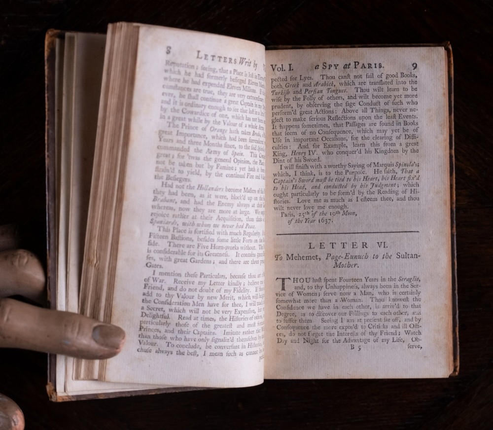 An eight-volume set of 18th-century leather-bound books standing upright with visible raised spine bands and gilt titles. View X