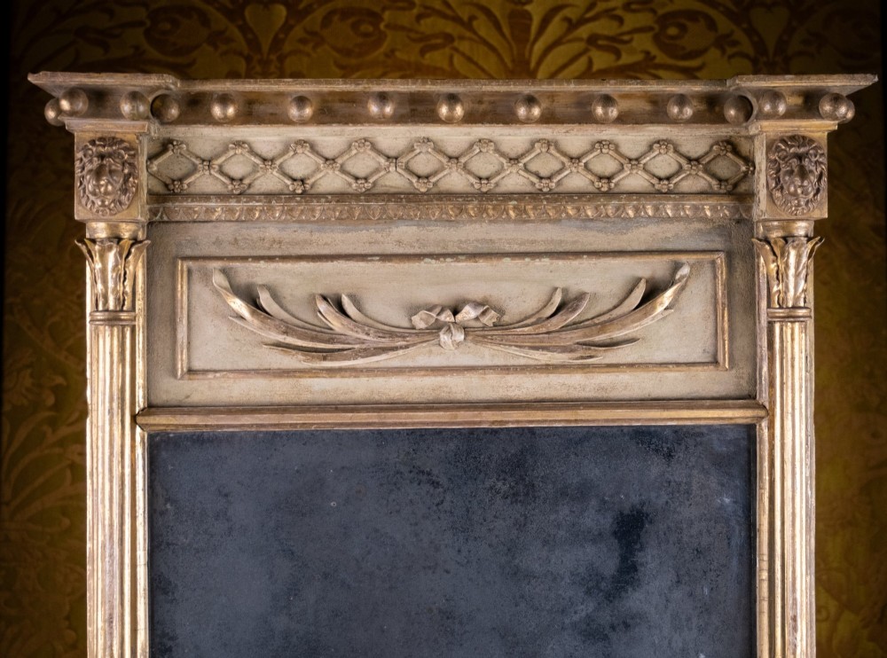 A large Regency style painted and gilded pier mirror featuring classical fluted columns, lion mask corner accents, a ball-ornament cornice, and distressed mirror glass. View II