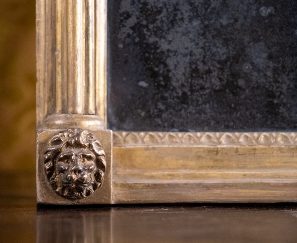 A large Regency style painted and gilded pier mirror featuring classical fluted columns, lion mask corner accents, a ball-ornament cornice, and distressed mirror glass. View V