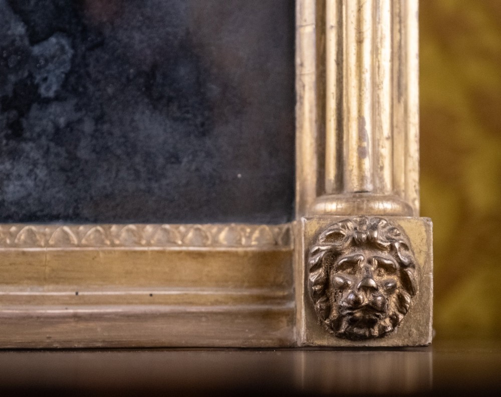 A large Regency style painted and gilded pier mirror featuring classical fluted columns, lion mask corner accents, a ball-ornament cornice, and distressed mirror glass. View VI