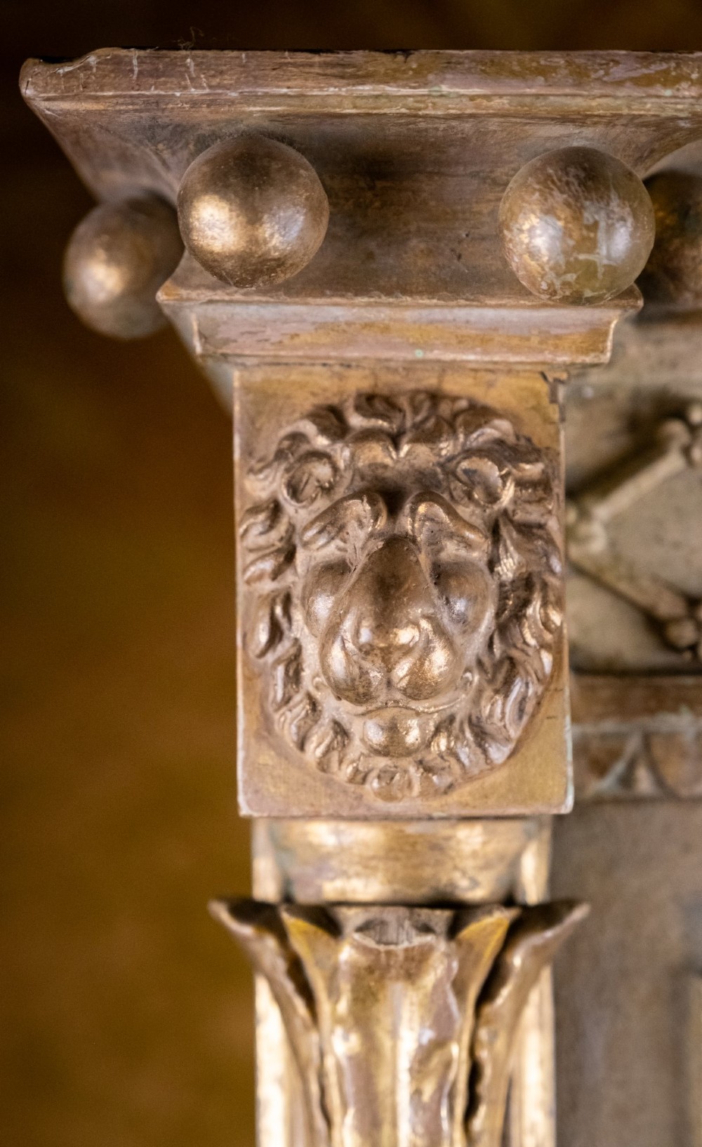 A large Regency style painted and gilded pier mirror featuring classical fluted columns, lion mask corner accents, a ball-ornament cornice, and distressed mirror glass. View X