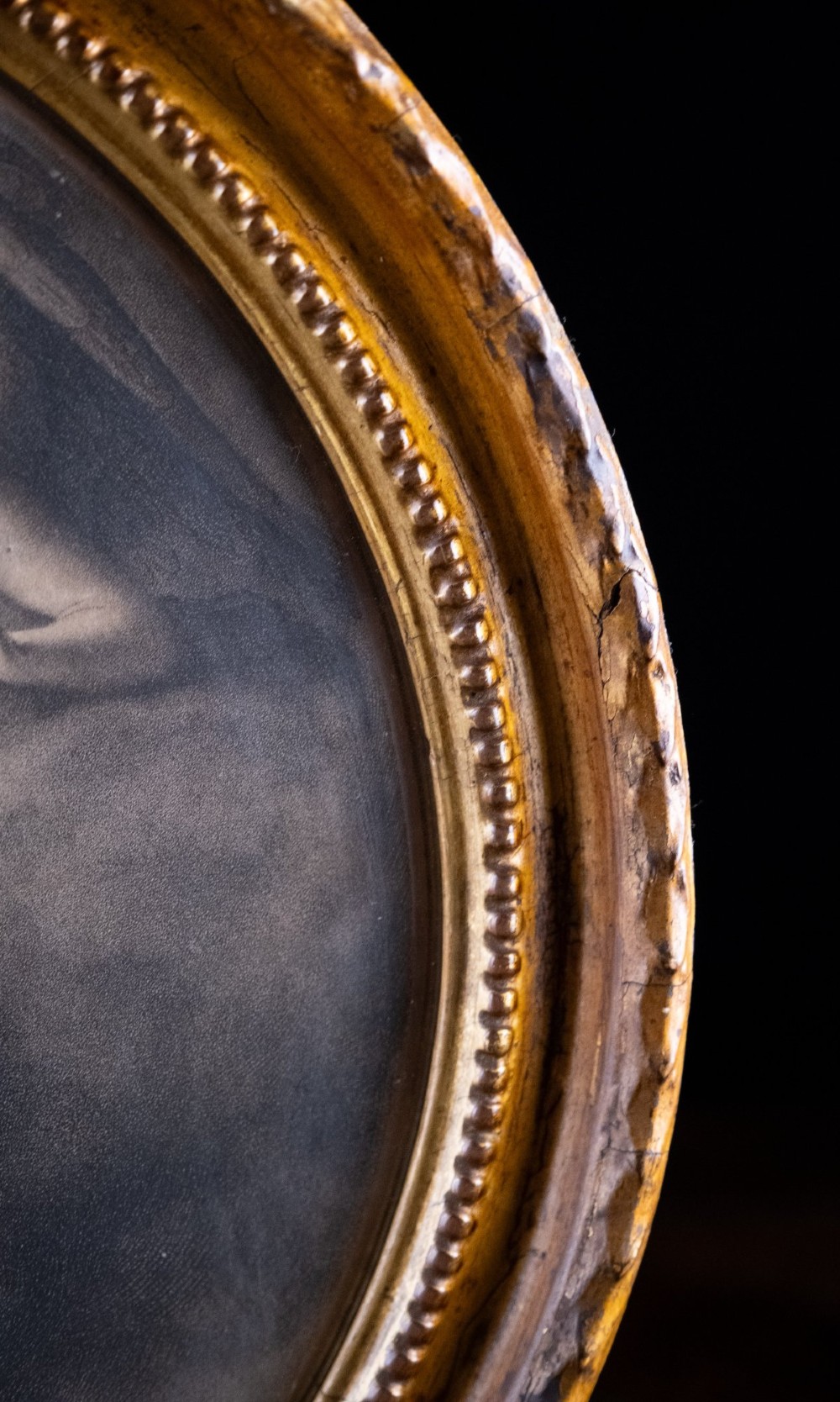 An eighteenth-century circular monochrome engraving depicting winged angels among clouds, set within a carved circular giltwood frame. View VII