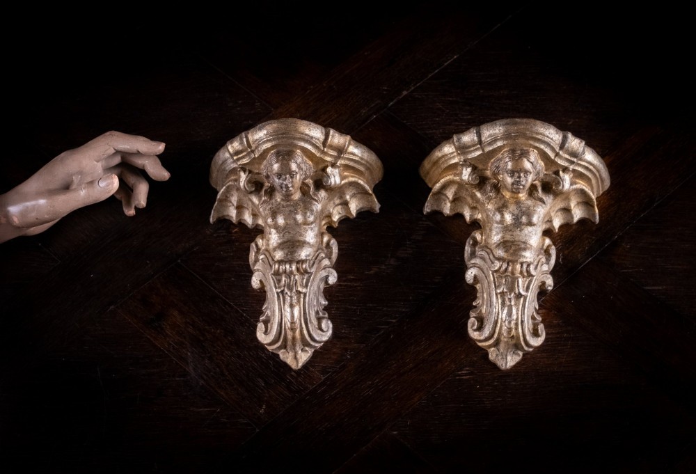 A pair of late Victorian gilt terracotta wall brackets shaped as winged sirens with decorative acanthus scrollwork bases. View II