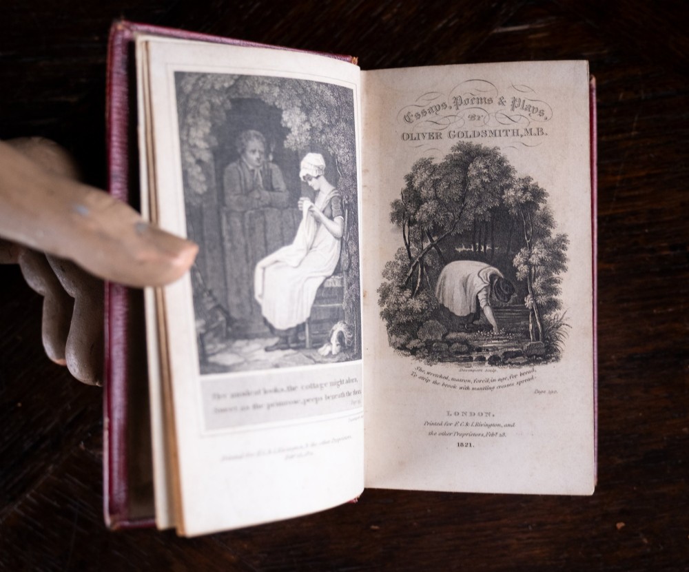An 1821 miniature book bound in red leather featuring gilt spine tooling, raised bands, and gold lettering. View IX