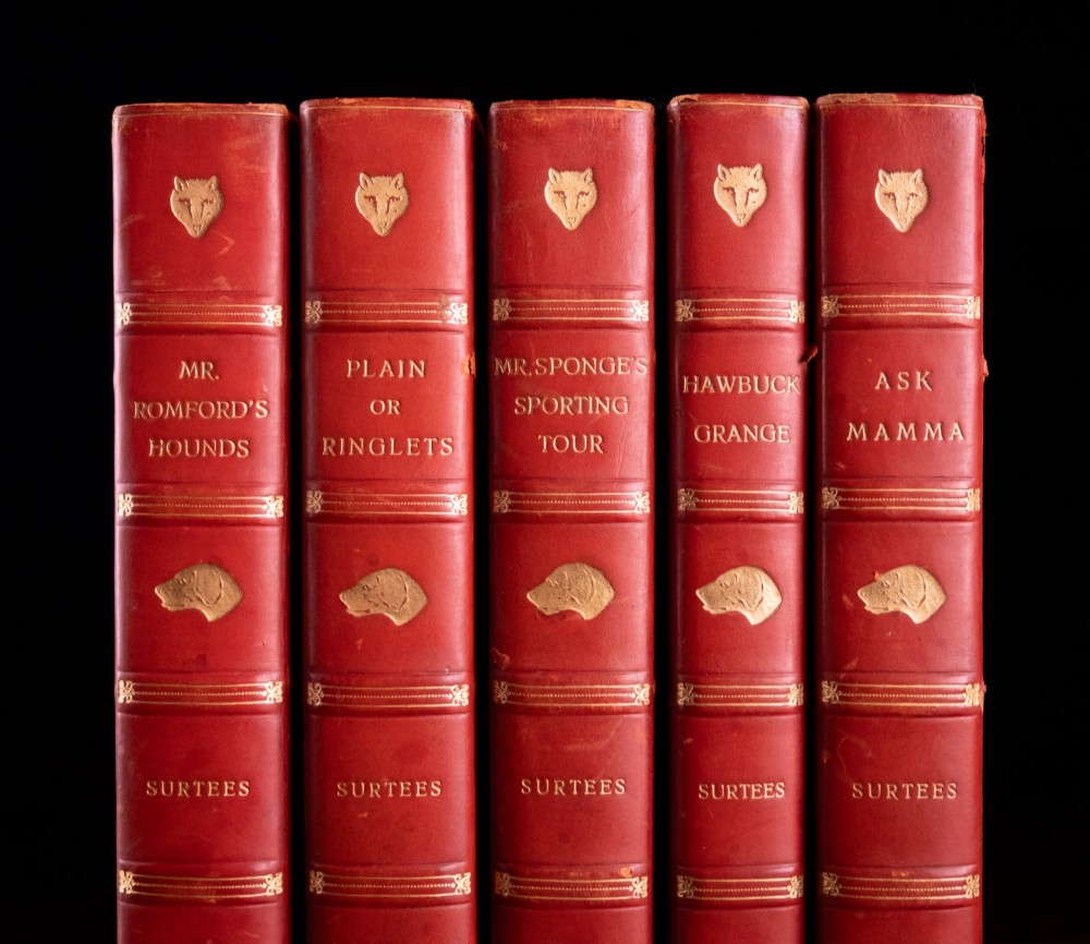 A five-volume set of red books featuring gilt spine lettering and embossed animal motifs. View II