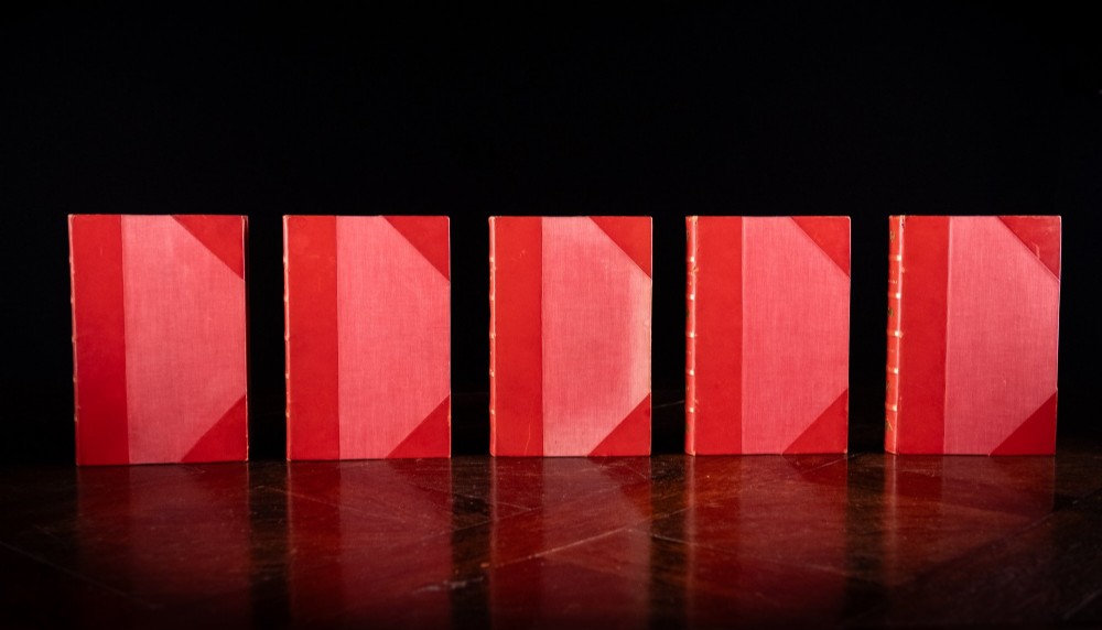 A five-volume set of red books featuring gilt spine lettering and embossed animal motifs. View III