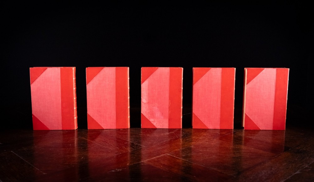 A five-volume set of red books featuring gilt spine lettering and embossed animal motifs. View IV