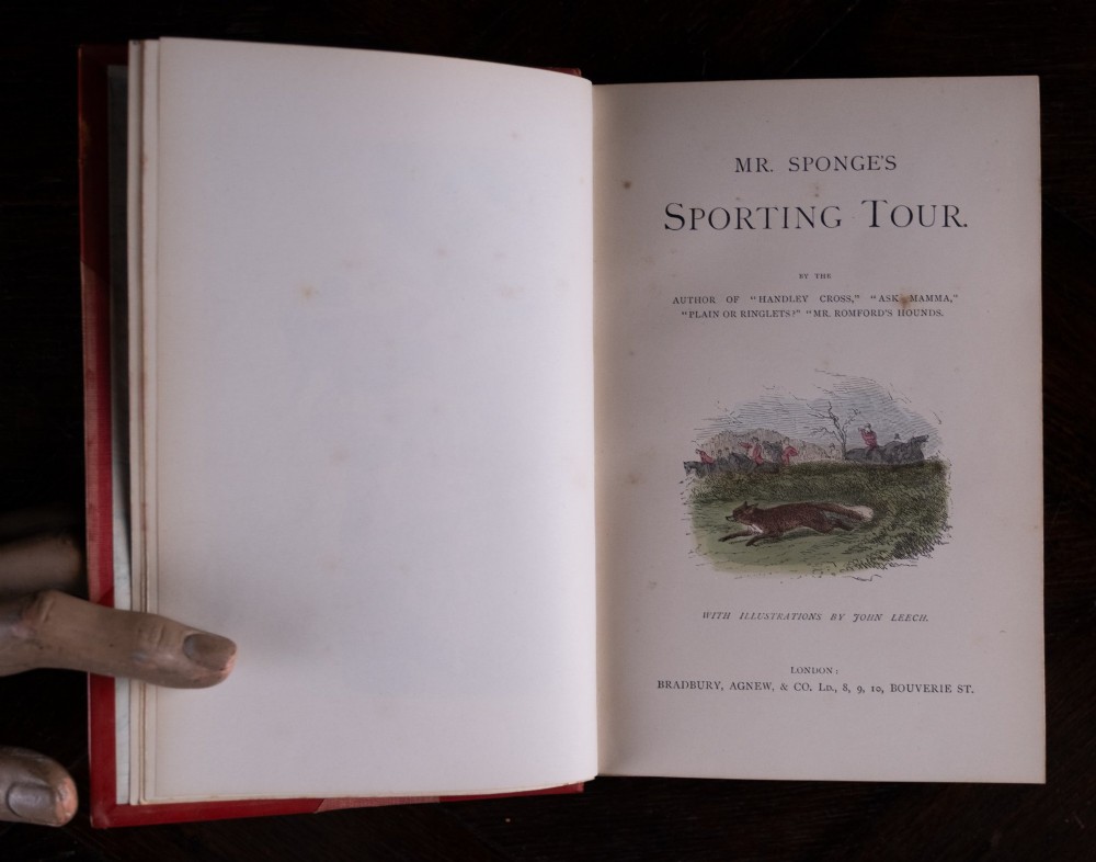 A five-volume set of red books featuring gilt spine lettering and embossed animal motifs. View XI