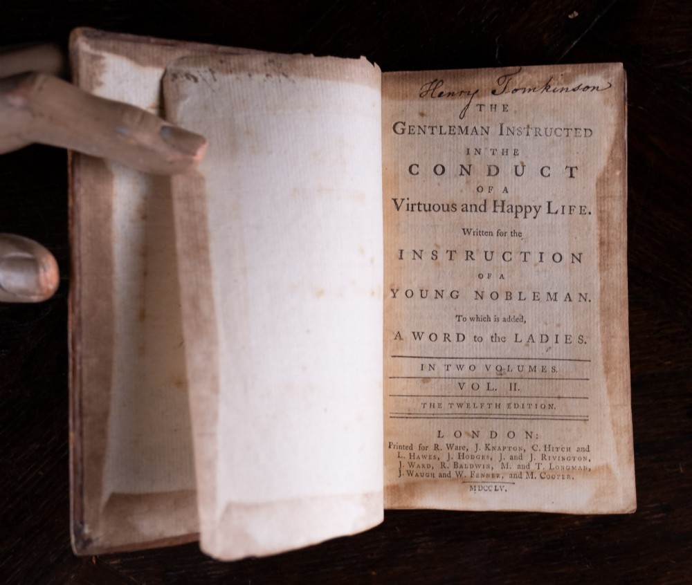 A two-volume set of 18th-century leather-bound books featuring gilt-tooled spine details and raised bands standing vertically. View VIII