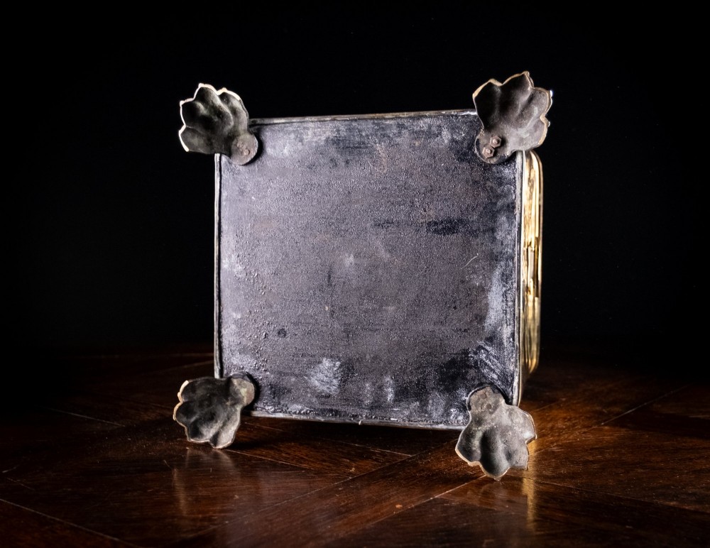 A square Victorian brass coal bin featuring a domed lid with a top ring handle, cast ram head mounts, drop ring handles, and four claw and paw feet. View XIV