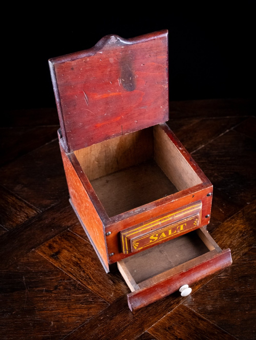 A nineteenth-century reddish-brown painted wooden wall-hanging salt box featuring gilt lettering reading SALT, a sloping hinged lid, and a small bottom drawer. View VII