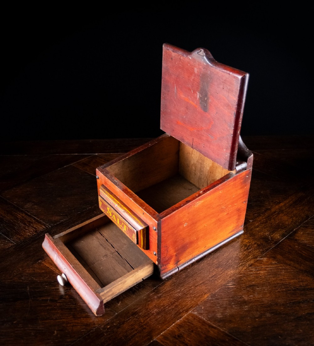 A nineteenth-century reddish-brown painted wooden wall-hanging salt box featuring gilt lettering reading SALT, a sloping hinged lid, and a small bottom drawer. View VIII