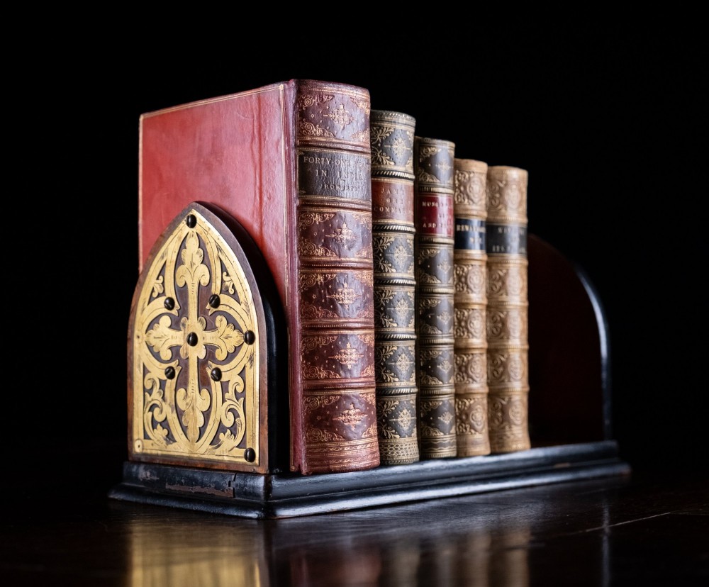 An antique dark walnut extending book slide featuring arched gothic ends detailed with pierced and engraved brass mounts. View II