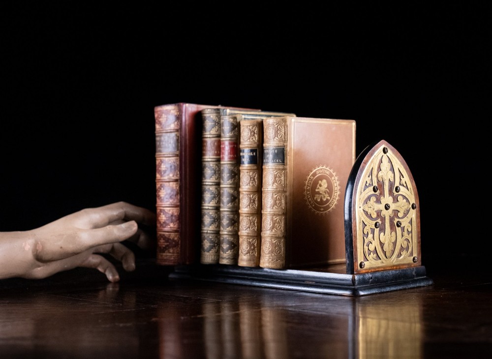 An antique dark walnut extending book slide featuring arched gothic ends detailed with pierced and engraved brass mounts. View X