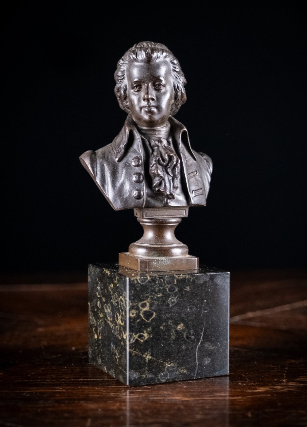 A dark patinated bronze bust of Wolfgang Amadeus Mozart mounted on a square black marble plinth. View V