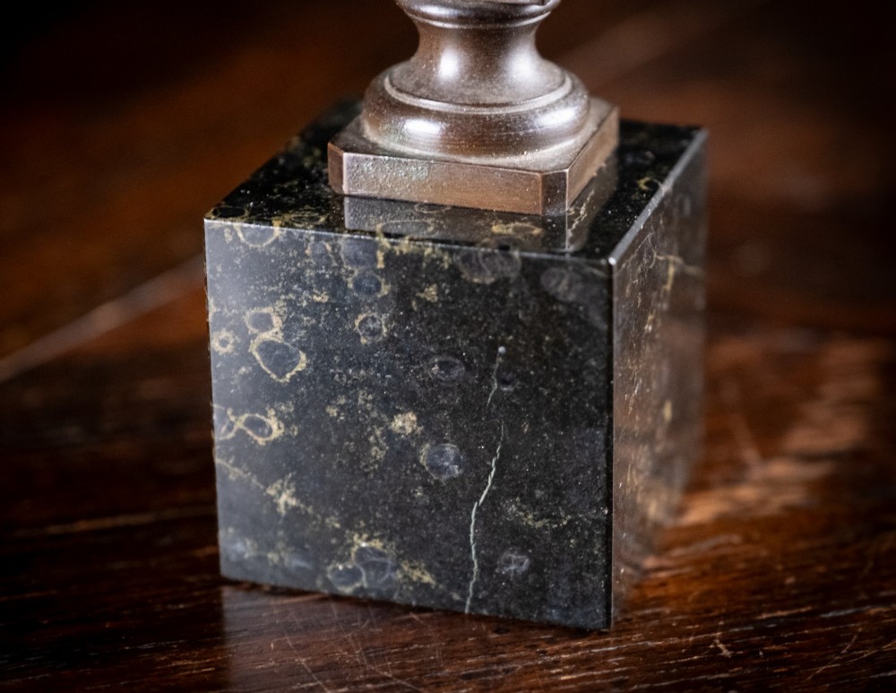 A dark patinated bronze bust of Wolfgang Amadeus Mozart mounted on a square black marble plinth. View VIII