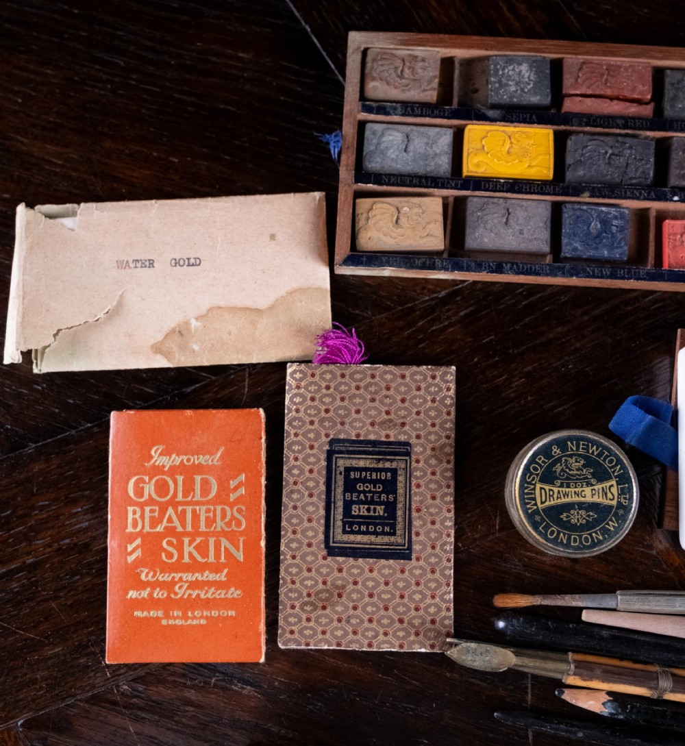 A Victorian mahogany artist watercolour box featuring an open lid lined with blue gilt-stamped paper, fitted compartments containing colour cakes, glass dishes, and a lower drawer holding a ceramic palette. View XII