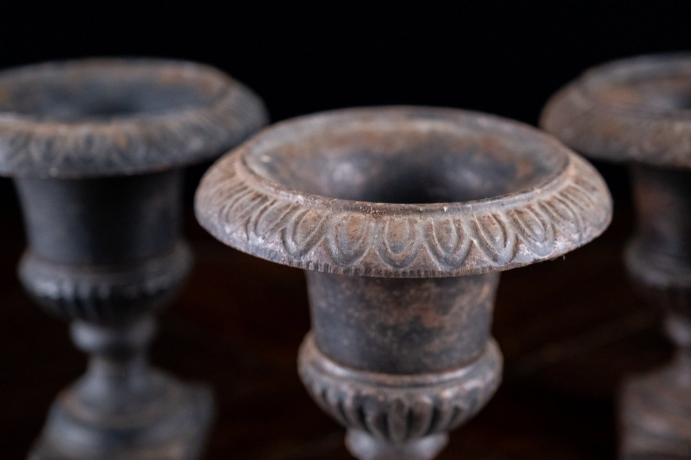 A set of three miniature cast iron urns featuring fluted campana bodies and square pedestal bases with a dark patinated finish. View III