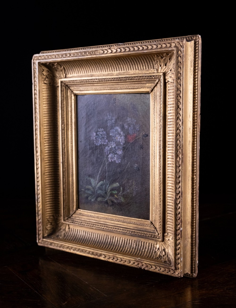 A 19th-century oil painting on canvas depicting purple flowers and a small red butterfly set within an ornate fluted gilt frame. View VII