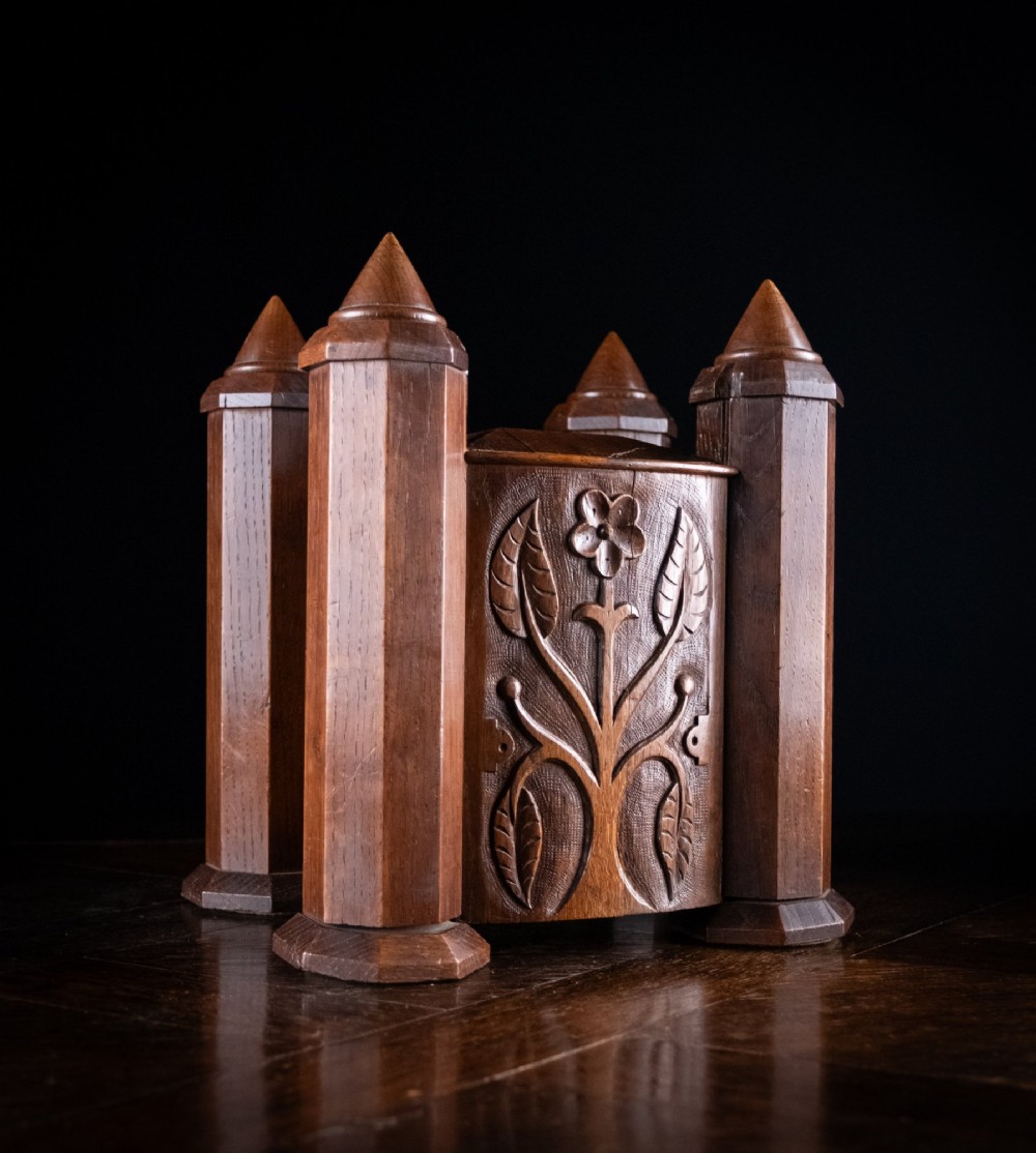 A 19th-century carved oak jewellery box designed like a castle with four corner turrets, floral relief panels, and small drawers. View II