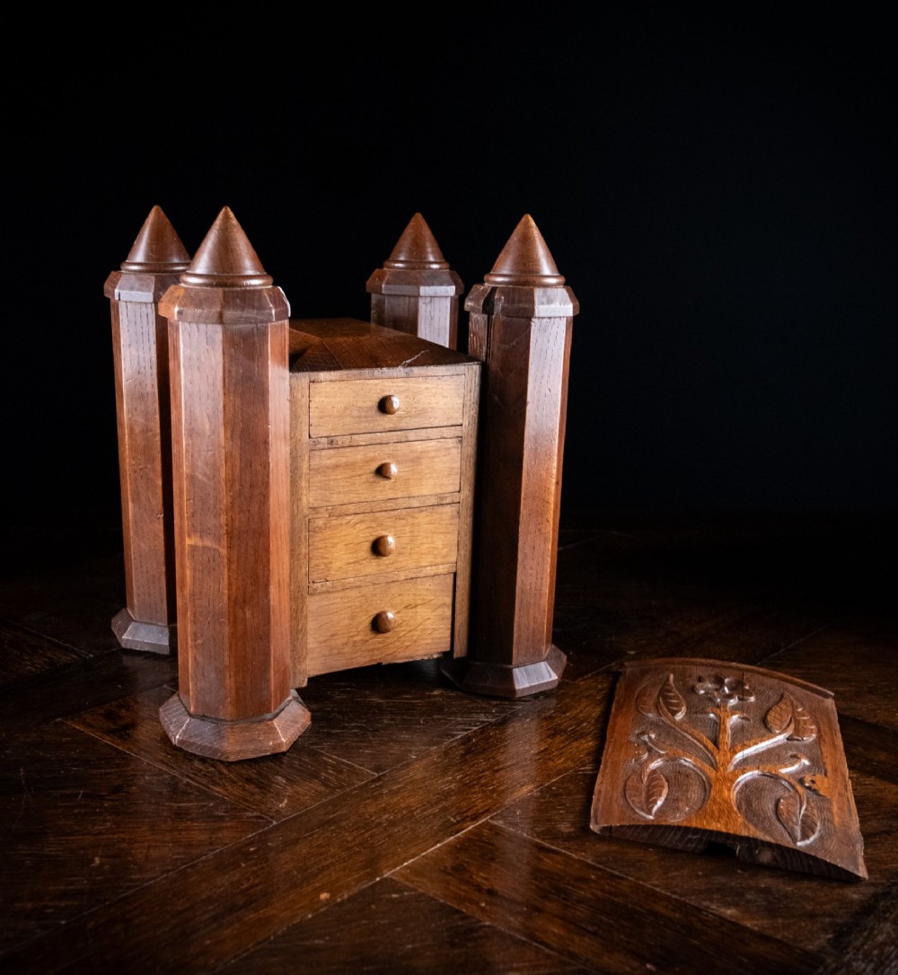 A 19th-century carved oak jewellery box designed like a castle with four corner turrets, floral relief panels, and small drawers. View VIII