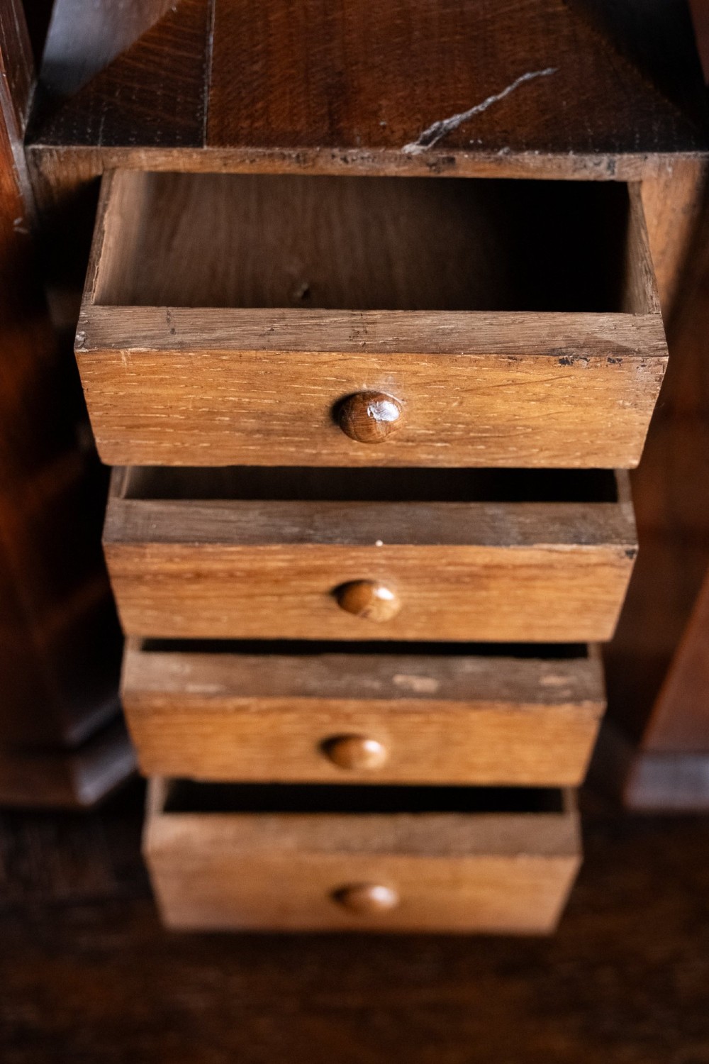 A 19th-century carved oak jewellery box designed like a castle with four corner turrets, floral relief panels, and small drawers. View X